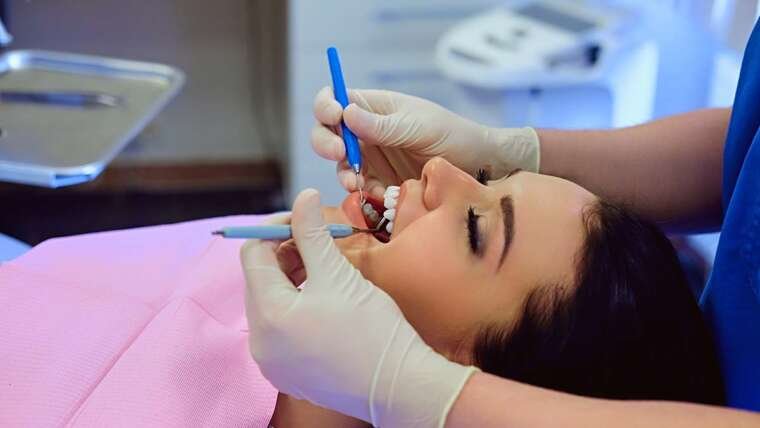 Dentist performing preventive dental checkup during routine professional teeth examination
