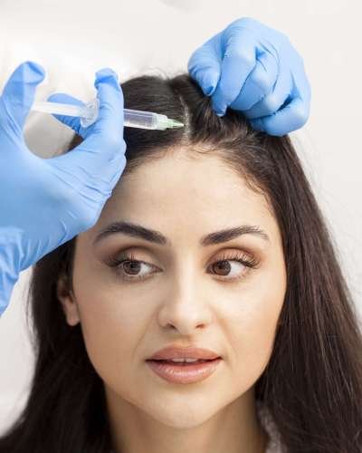 hair mesotherapy procedure in cosmetology clinic, cosmetologist doctor makes injection of botulinum toxin into girl's head